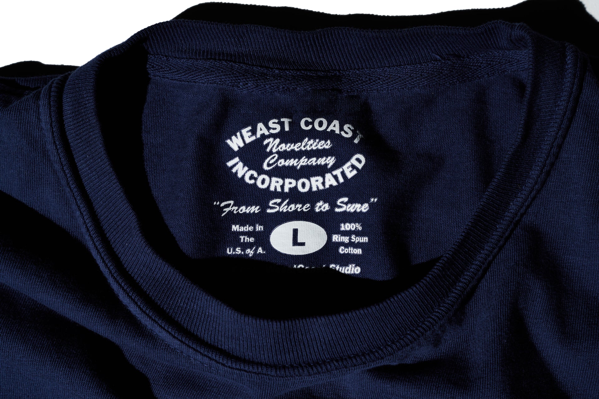 detail of Navy t-shirt with crackle print weast coast arched letters